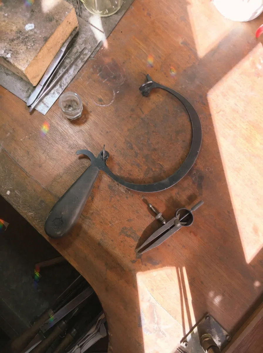 Mesa de trabajo con herramientas de orfebrería bañadas en luz